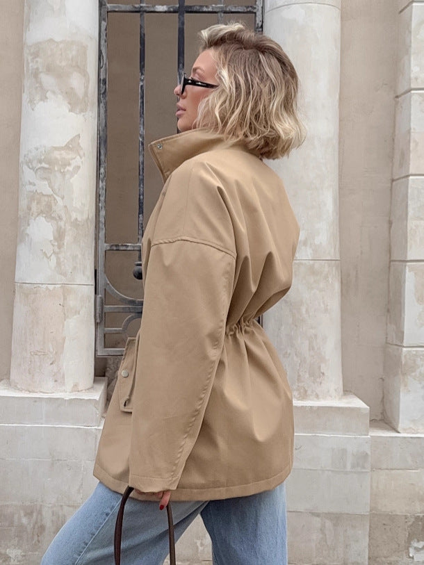 A mid-length coat with a stand-up collar and drawstring at the waist for women