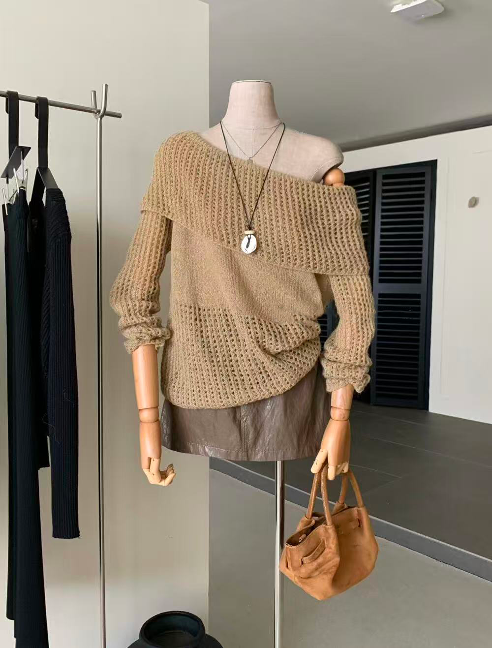 A lady's knitted top paired with a brown leather skirt